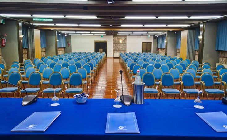 Interior of a conference room with blue chairs arranged neatly for a meeting.