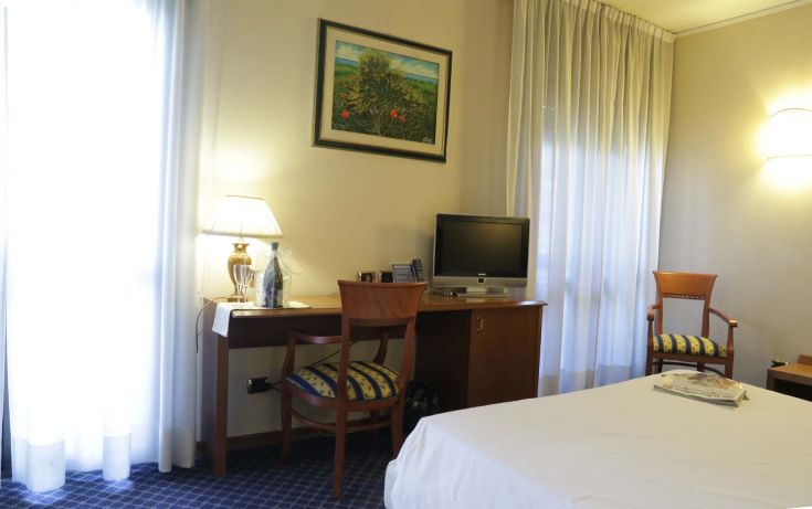 Simple hotel room with a desk and a television, perfect for a quiet stay.