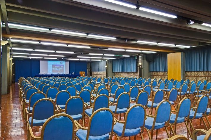 Spacious event hall with neatly arranged chairs and a bright atmosphere.