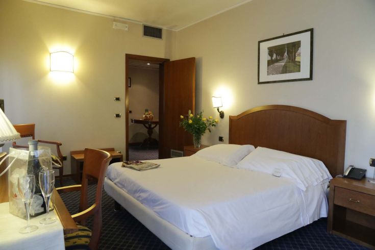 Simple and comfortable room of the Garden Hotel, perfect for a relaxing stay.