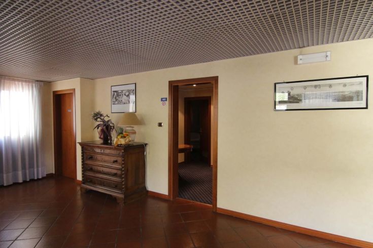 A simple corridor in a building, featuring natural light coming through the windows.