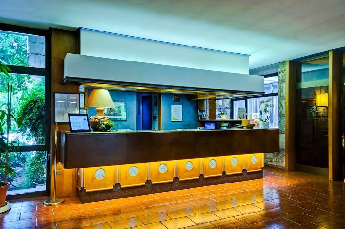 A reception area of the Garden Hotel, featuring a calm and bright atmosphere ideal for welcoming guests.
