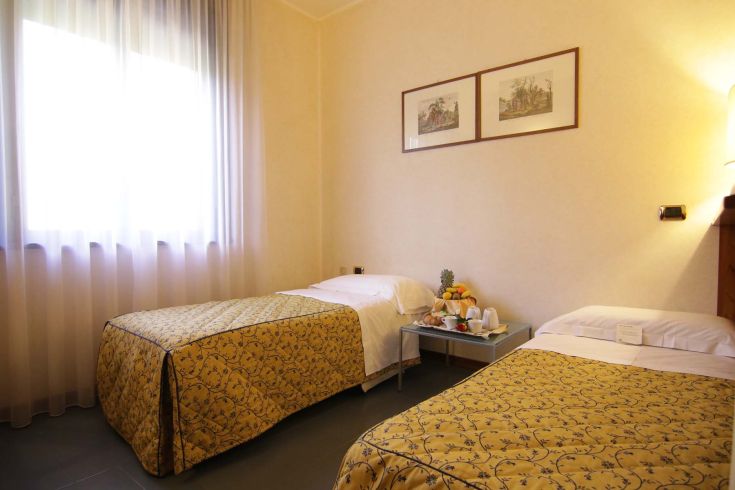 A comfortable room with single beds, simple furnishings, and thoughtful details, ideal for relaxation.