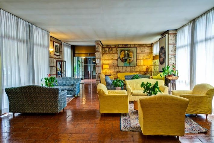 A simple living room design featuring soft-colored sofas and some green plants for a natural touch.