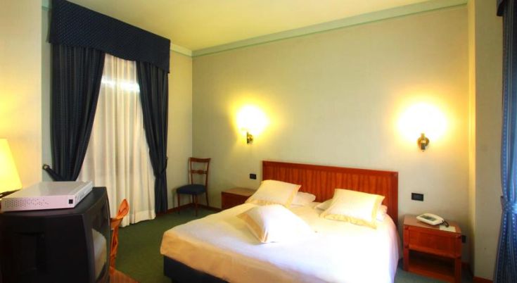 Camera semplice con letti singoli, dotata di comfort essenziali per un soggiorno sereno.