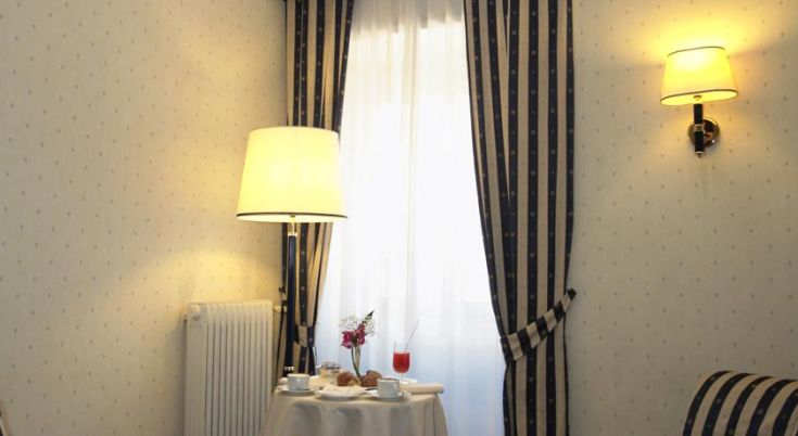 Angolo di relax in un ambiente domestico, con lampada e tavolo decorato, ideale per una pausa tranquilla.