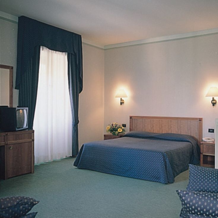 Camera accogliente con letto matrimoniale e arredi semplici, perfetta per un soggiorno rilassante.