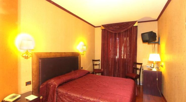 Camera confortevole con letto matrimoniale e mobili dallo stile sobrio.