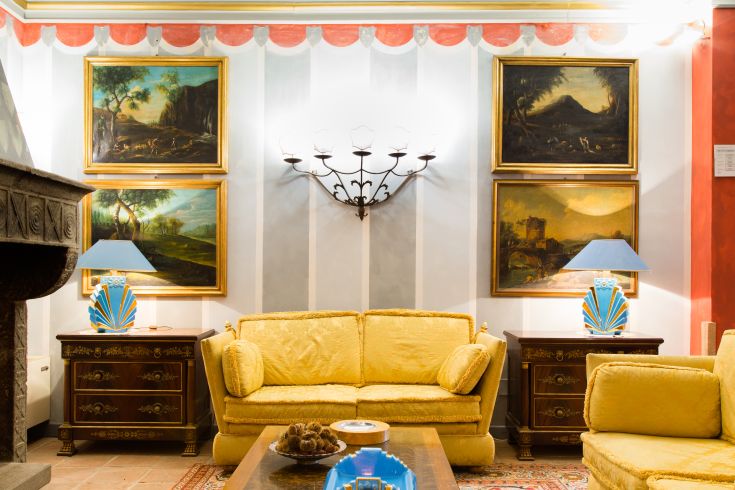 Soggiorno arredato con divani gialli e elementi decorativi sui muri.