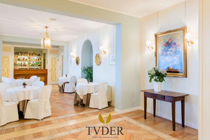 Comfortabile sala da pranzo con tavoli apparecchiati e decorazioni semplici.