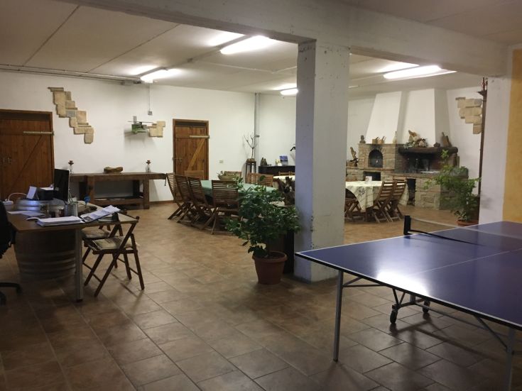 Interno di un agriturismo, ideale per momenti di relax e svago, con arredi semplici e un'atmosfera raccolta.