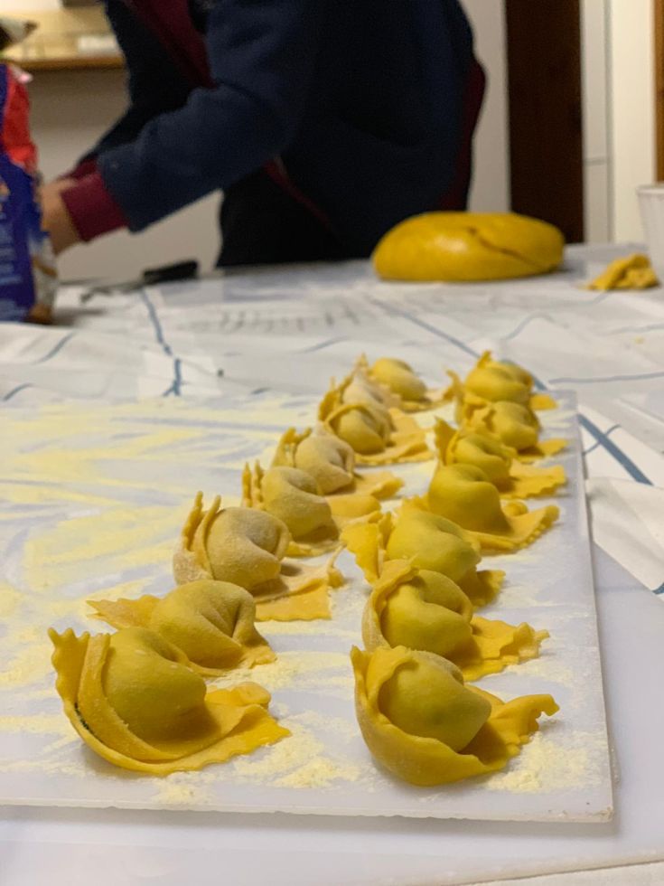 Dettaglio di tortellini freschi in fase di preparazione su un tavolo da cucina.