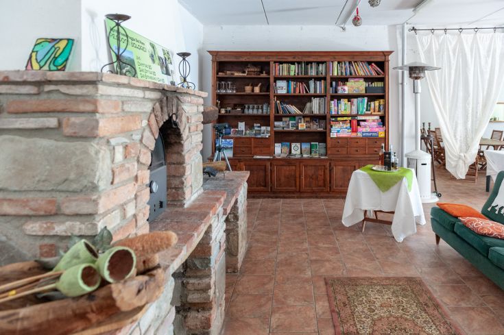 Un confortevole ambiente interno dotato di camino, libreria e angoli per relax, ideale per una pausa tranquilla.