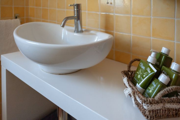 Bagno semplice con lavandino contemporaneo e articoli per la cura personale. Ambiente sereno.