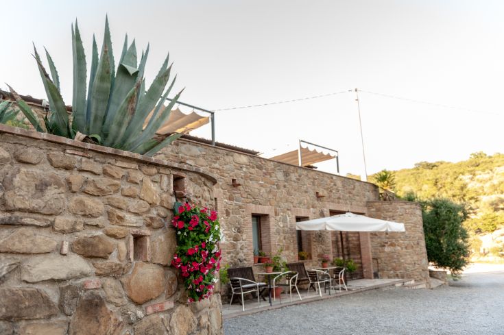 Un edificio in pietra circondato da alberi e vegetazione, un luogo tranquillo per godersi la natura umbra.