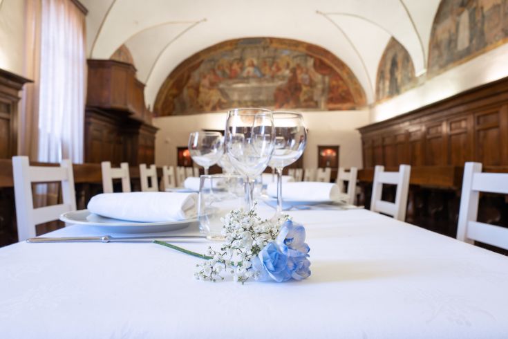 Ein wunderschön gedeckter Tisch in einem eleganten Palast, geschmückt mit frischen Blumen und ordentlich angeordnetem Besteck für ein Beisammensein.