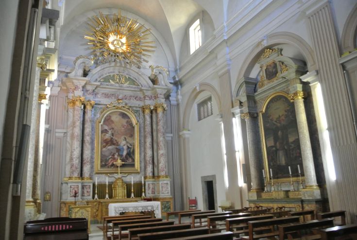 Innenraum eines historischen Palastes mit schlichten Dekorationen und gut beleuchteten Räumen in einer ruhigen Atmosphäre.