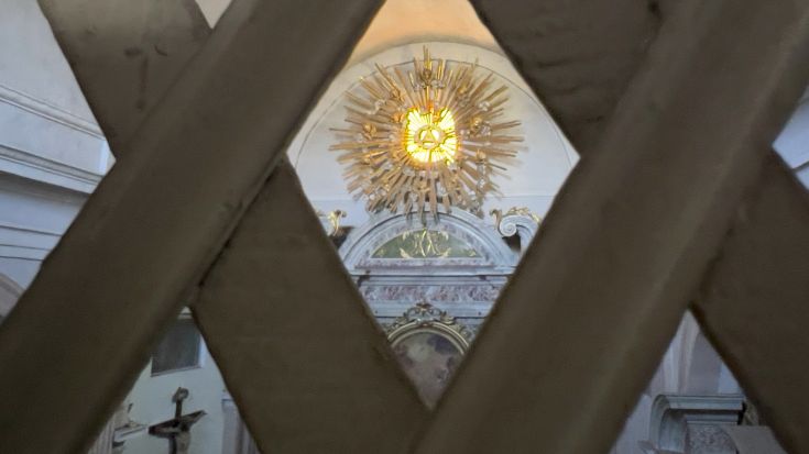 Szene eines alten Klosters mit aufwendigen architektonischen Details und einem goldenen Drapé.