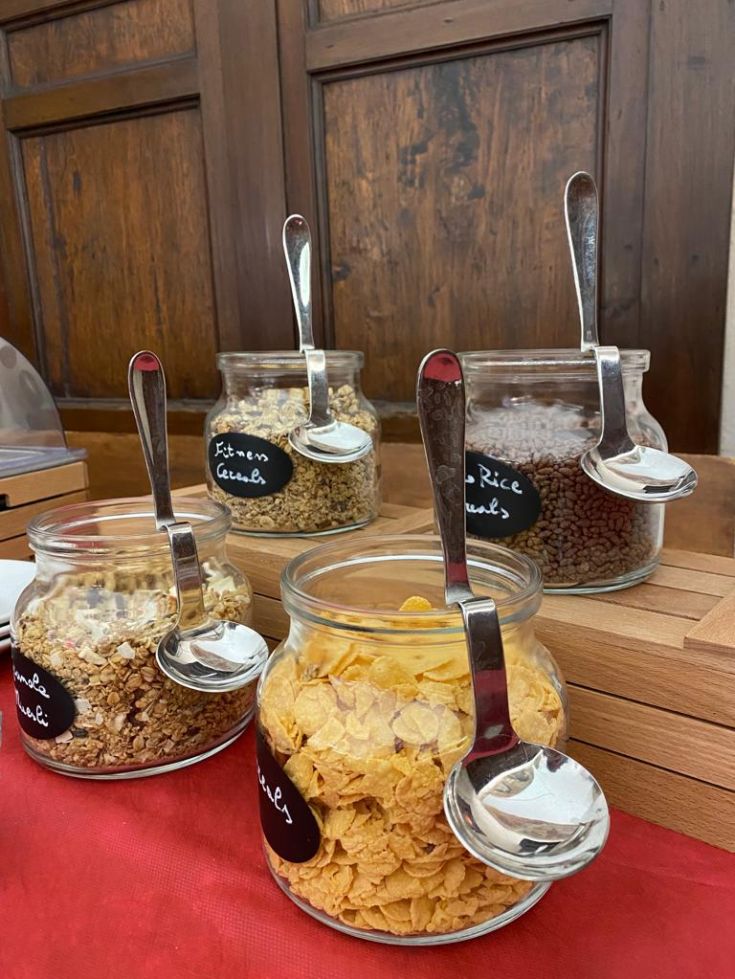 Eine Auswahl an frischen Cerealien in Glasbehältern, ideal für ein gesundes Frühstück.