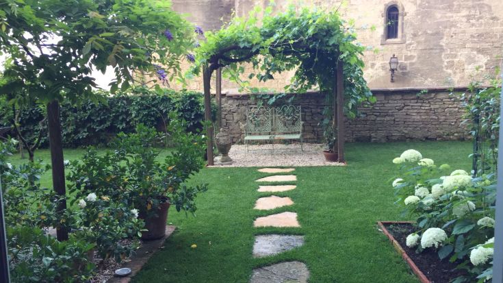 Una residenza storica con un giardino ben curato, ideale per momenti di tranquillità all'aperto.