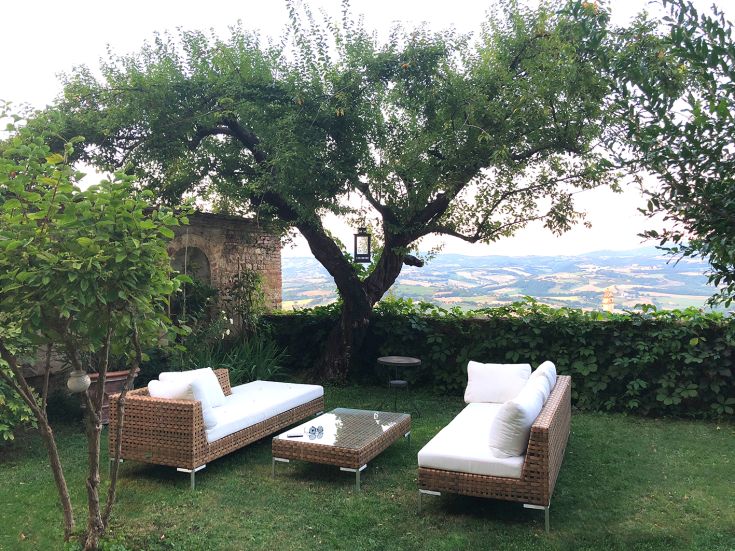 Un angolo accogliente in giardino, con divani confortevoli e uno scenario naturale tranquillo.
