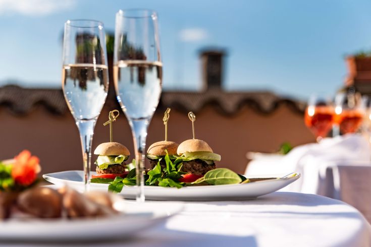 A selection of burgers and champagne glasses in an outdoor setting, perfect for socializing.