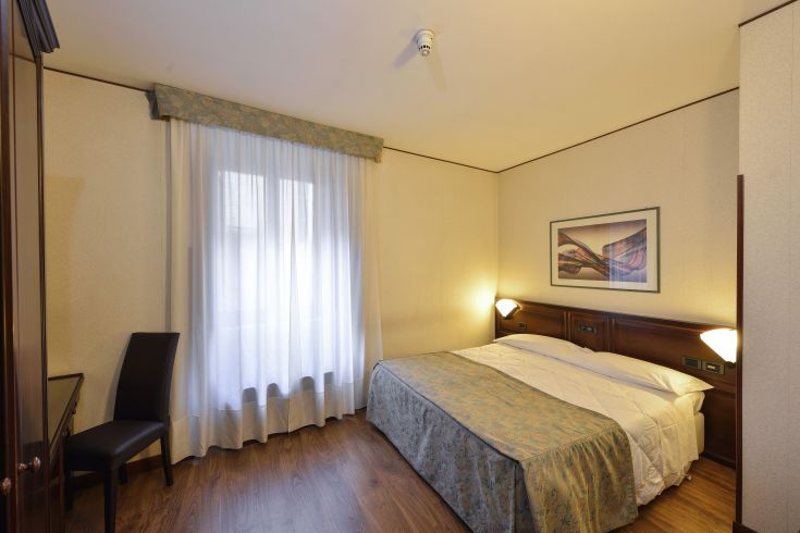 Simple room with a double bed and natural light. A comfortable and functional environment.