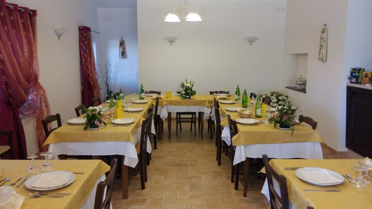 Une salle à manger accueillante, aménagée confortablement avec une table centrale et des chaises.