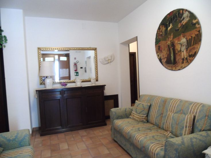 Salon informel avec des canapés confortables et un grand miroir sur le mur.