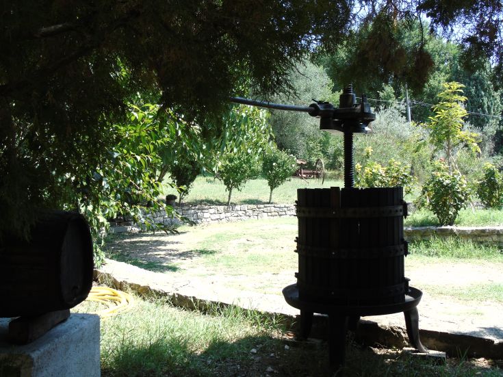 Un pressoir à fruits utilisé pour l'extraction de jus, situé dans une ferme entourée de verdure.