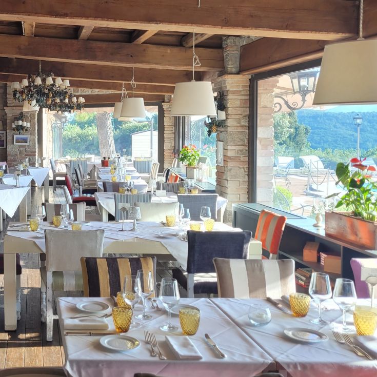 An elegant restaurant with sophisticated decor, overlooking the serene Umbrian countryside.