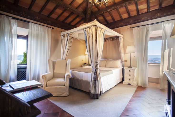 Room with a canopy bed overlooking the Umbrian countryside, perfect for a relaxing stay.