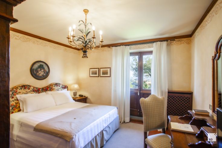 Simple room with a view of the Umbrian countryside, featuring traditional furnishings and essential comforts.