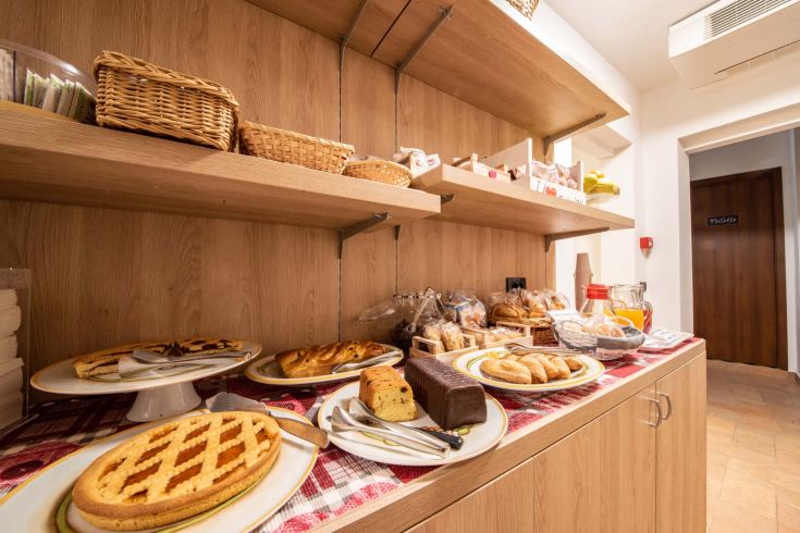 Buffet con dolci e bevande per una colazione piacevole in un ambiente confortevole.