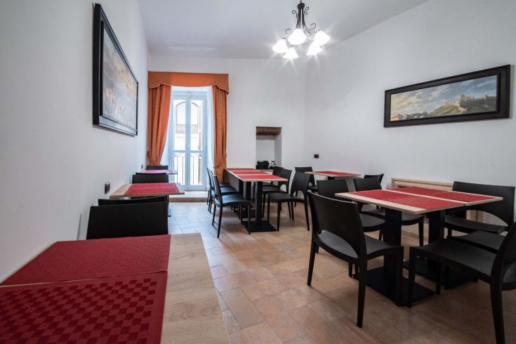 Spazio confortevole con tavoli e sedie, adatto per colazioni in un contesto alberghiero.