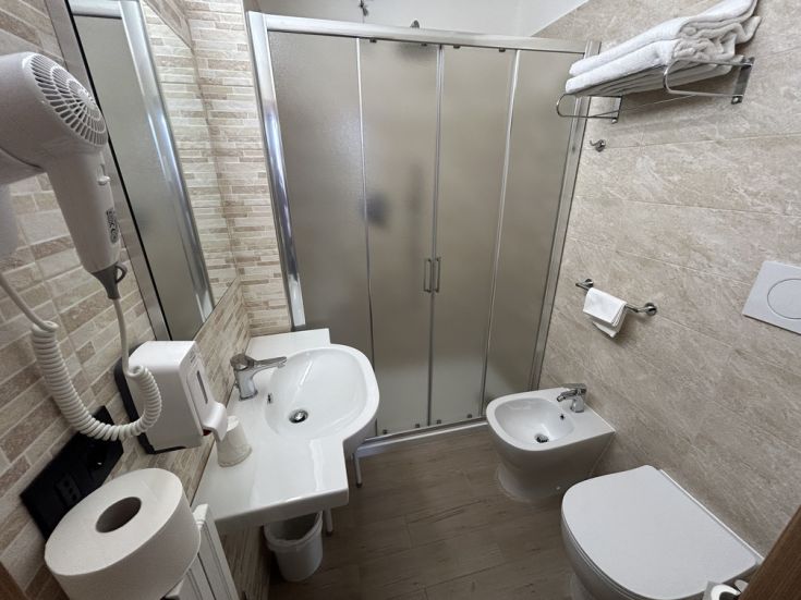 Interno di un bagno moderno, con doccia e lavabo. L'ambiente è luminoso e ben strutturato.