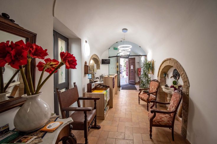 Un ingresso semplice e grazioso, con fiori e dettagli curati, per un soggiorno a Assisi.