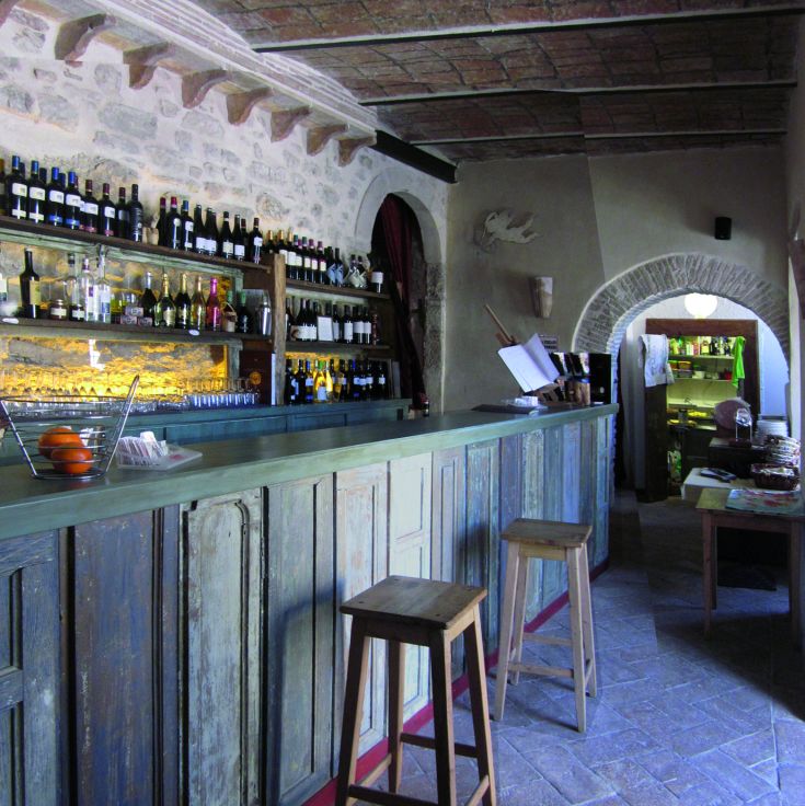 Innenansicht einer traditionellen Bar mit Regalen voller Getränke und einer einfachen, informellen Atmosphäre.