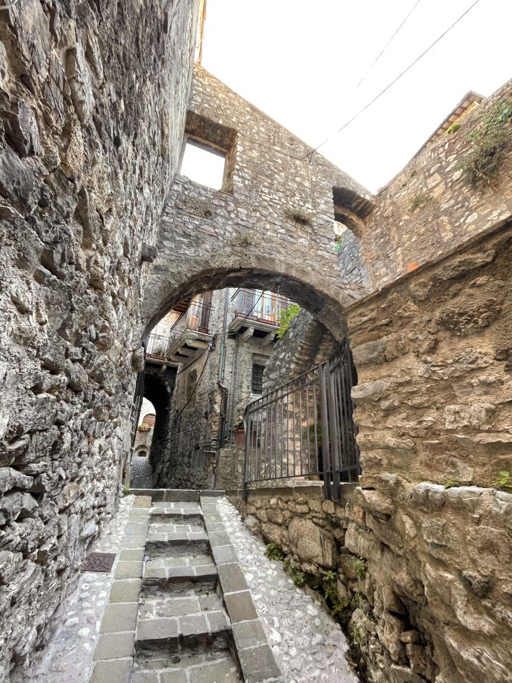 Ein historisches Dorf mit gepflasterten Straßen und Steinbögen, das eine zeitlose Atmosphäre ausstrahlt.