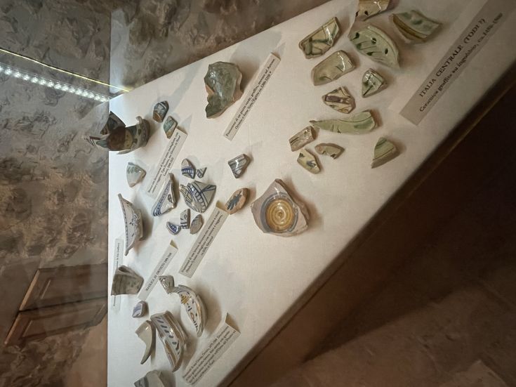 Ausstellung antiker Keramikfragmente aus verschiedenen Epochen in einem Museum, das lokale handwerkliche Traditionen hervorhebt.