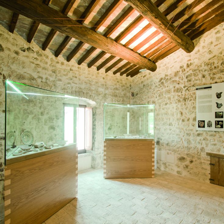 Innenansicht eines Gebäudes mit Steinwänden und Fenstern, die eine historische Atmosphäre vermitteln.