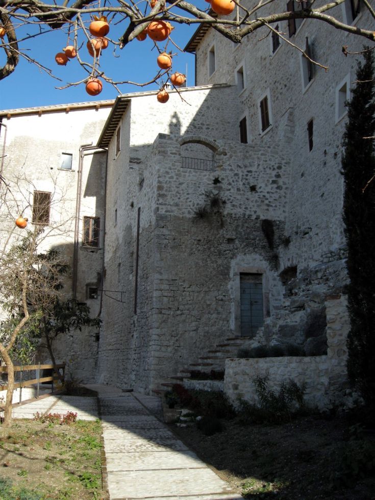 Panorama von Borgo San Valentino mit Steinbauten und Obstbäumen in einer ruhigen Atmosphäre.