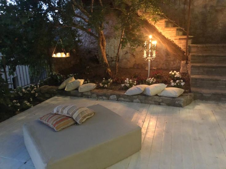 Ein gemütlicher Außenbereich mit Kissen und Pflanzen, ideal zum Entspannen an der frischen Luft.