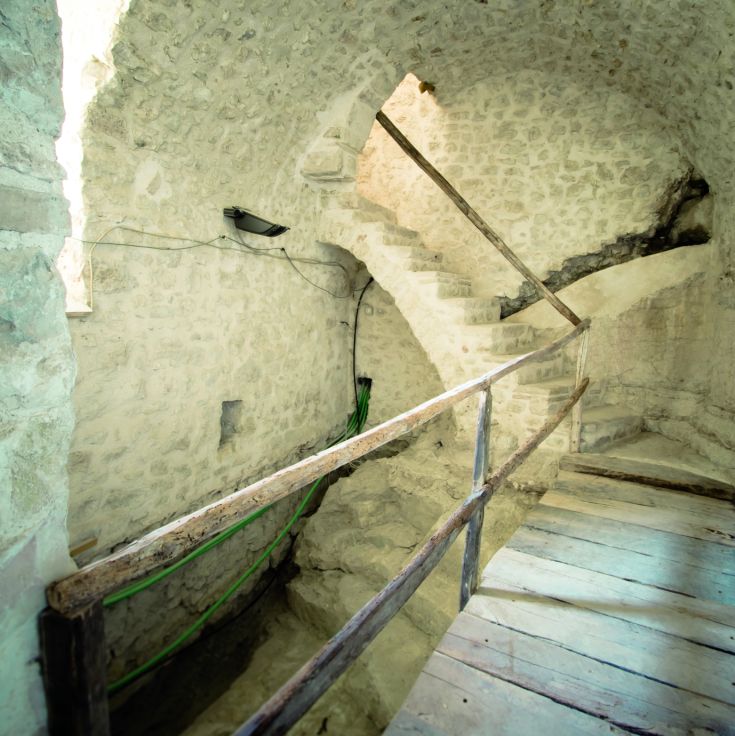 Inneres eines Gebäudes mit Steintreppen und markanten architektonischen Elementen.