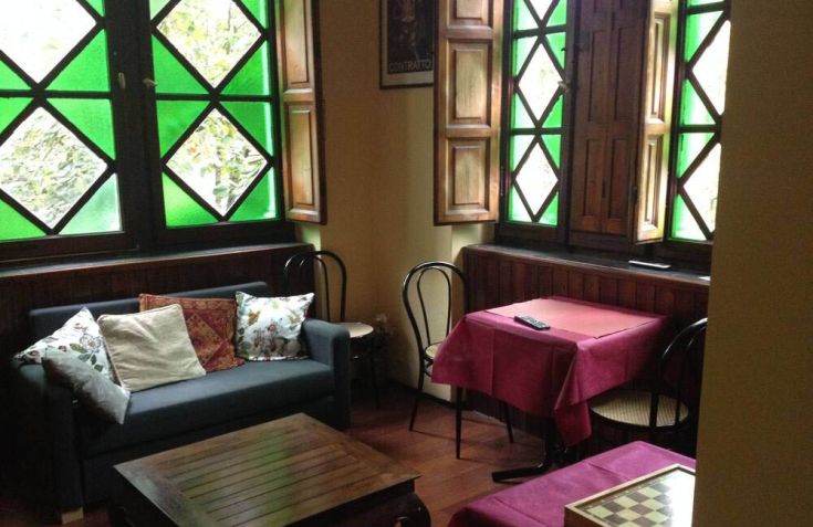 Spazio di un hotel caratterizzato da finestre eleganti e arredi semplici e confortevoli.