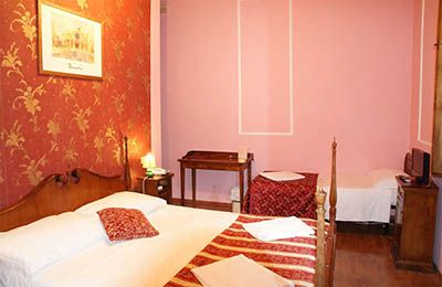 Camera in un hotel con elementi decorativi in stile Liberty, semplice e accogliente.