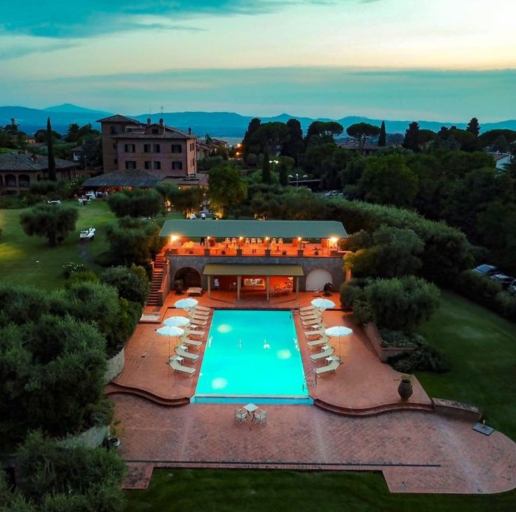 Eine Szene einer Villa mit Pool, umgeben von einem gepflegten und hellen Garten.