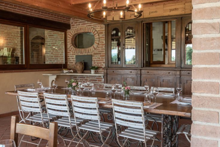 Ein gemütliches Restaurant mit einem großen Holztisch, einfach dekoriert und mit gemauerten Wänden.