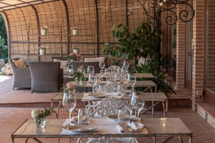 Ein Restaurant mit gut gedeckten Tischen, Zierpflanzen und einer sorgfältig gestalteten Einrichtung.