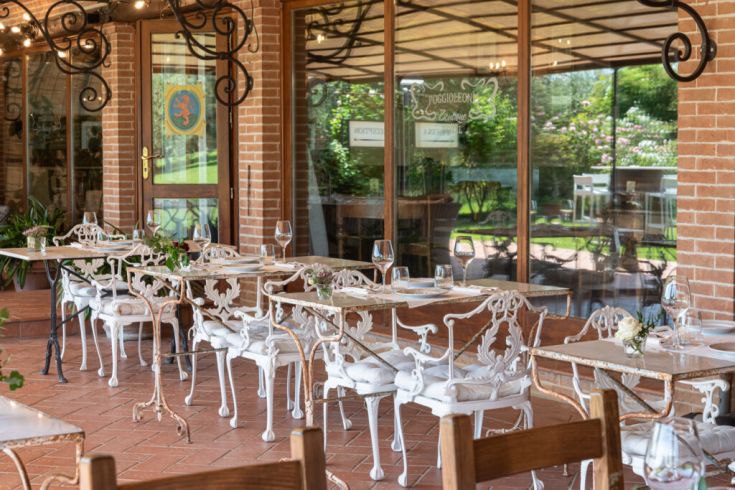 Ein Außenbereich mit Schreibtischen aus Schmiedeeisen, umgeben von Pflanzen.